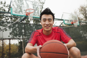 バスケとボールを抱えたスポーツウェアの男性