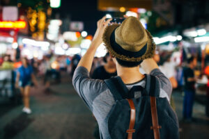 夏の夜、市内観光をしながら写真を撮る男性の後ろ姿