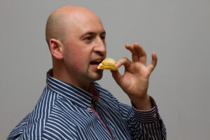 ポテトチップスを食べる坊主頭の男性