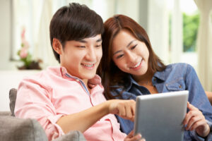 タブレット端末をのぞき込む男女